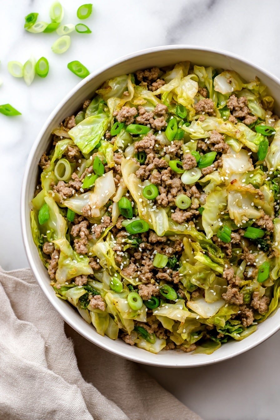 A white bowl filled with cooked ground meat mixed with light green and slightly browned cabbage pieces scattered evenly throughout. Bright green slices of green onion are sprinkled on the top, along with small white sesame seeds that add texture. The dish looks glossy with a light brown sauce coating the meat and cabbage. Some green onion slices lie on the white marbled surface around the bowl, and a beige cloth is placed to the side. Photo taken with an iphone --ar 2:3 --v 7 — Low Carb Mongolian Ground Beef and Cabbage, Healthy beef and cabbage stir-fry, Low carb Asian beef and cabbage, Easy low carb dinner, Low carb beef recipes