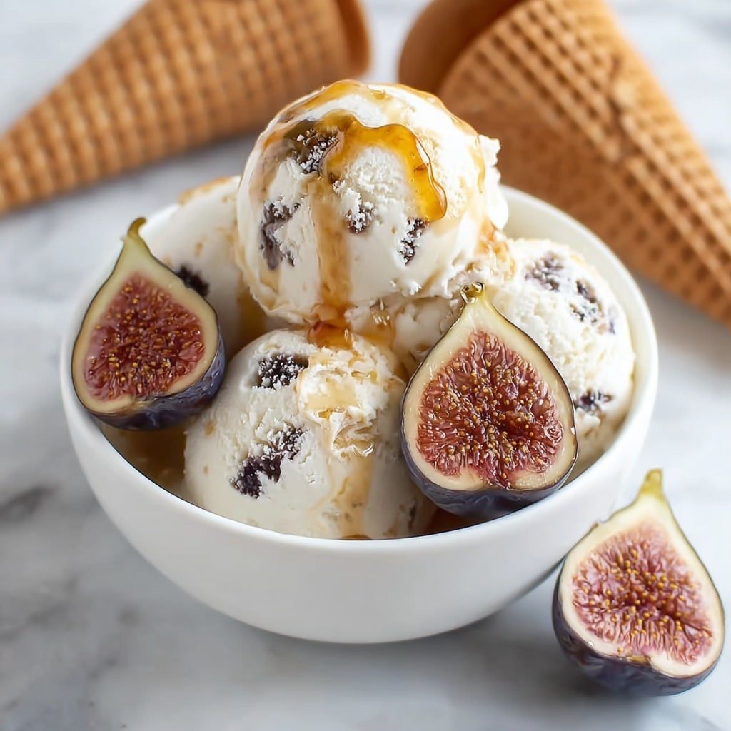 The image shows a white bowl filled with three scoops of creamy white ice cream with visible dark fig pieces mixed in. There is a golden honey-like syrup drizzled over the ice cream, giving a shiny texture on top. Around the bowl, there are two halved figs with dark purple skin and detailed pinkish interiors with seeds. In the background, there are some waffle cones slightly out of focus. The whole scene is set on a white marbled surface. photo taken with an iphone --ar 1:1 --v 7 — Honey-Drizzled Fig Ricotta Ice Cream, fig ricotta ice cream, honey dessert recipes, roasted fig ice cream, easy gourmet ice cream
