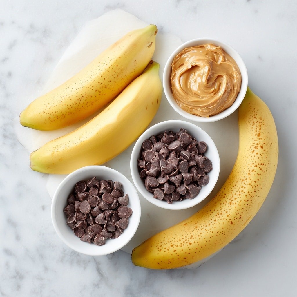 Flat lay of three ripe bananas with bright yellow skins and brown speckles, a small white ceramic bowl of creamy natural peanut butter, a small white ceramic bowl filled with shiny dark chocolate chips, a small white ceramic bowl holding clear, melted coconut oil, arranged in perfect symmetry and balanced proportions, placed on a clean white marble surface, soft natural light, photo taken with an iPhone, professional food photography style, fresh ingredients, white ceramic bowls, no bottles, no duplicates, no utensils, no packaging --ar 1:1 --v 7 --p m7354639359234015250 — Chocolate Peanut Butter Banana Bites, easy banana dessert, healthy snack ideas, no-bake fruit treats, chocolate banana snack