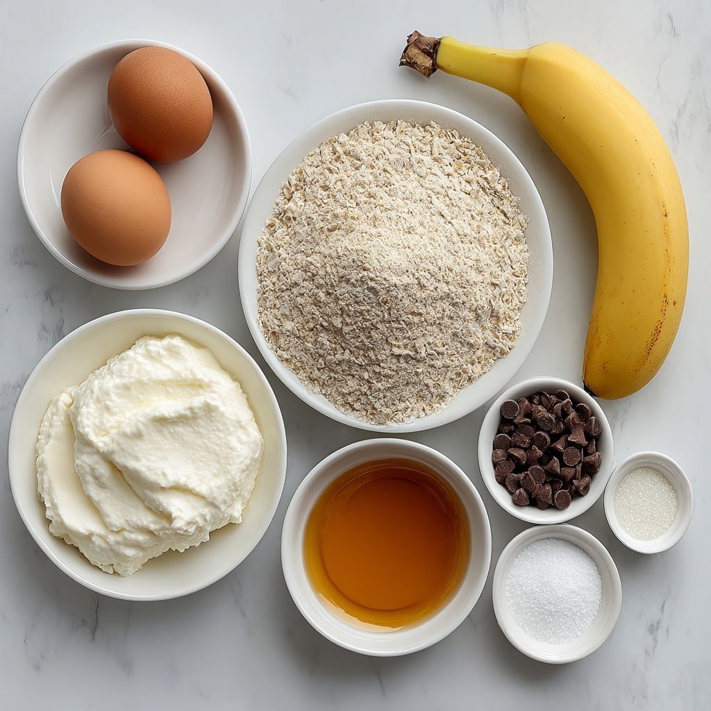 Flat lay of one large whole uncracked brown egg, a small mound of creamy white Greek yogurt on a simple white ceramic plate, one ripe peeled banana, a small white bowl filled with golden maple syrup, a small heap of light beige oat flour on a white plate, a smaller pile of pale almond flour beside it, a small white bowl containing clear milk, a few dark chocolate chips scattered neatly on a white plate, and small white ceramic dishes holding fine white baking powder and a pinch of salt, plus a tiny white bowl with amber vanilla extract, all arranged in perfect symmetry on a clean white marble surface, soft natural light, photo taken with an iPhone, professional food photography style, fresh ingredients, white ceramic bowls, no bottles, no duplicates, no utensils, no packaging --ar 1:1 --v 7 --p m7354639359234015250 — Healthy Greek Yogurt Banana Cake, Greek Yogurt Banana Cake, Healthy Banana Cake Recipe, Moist Banana Cake with Greek Yogurt, Easy Healthy Banana Cake